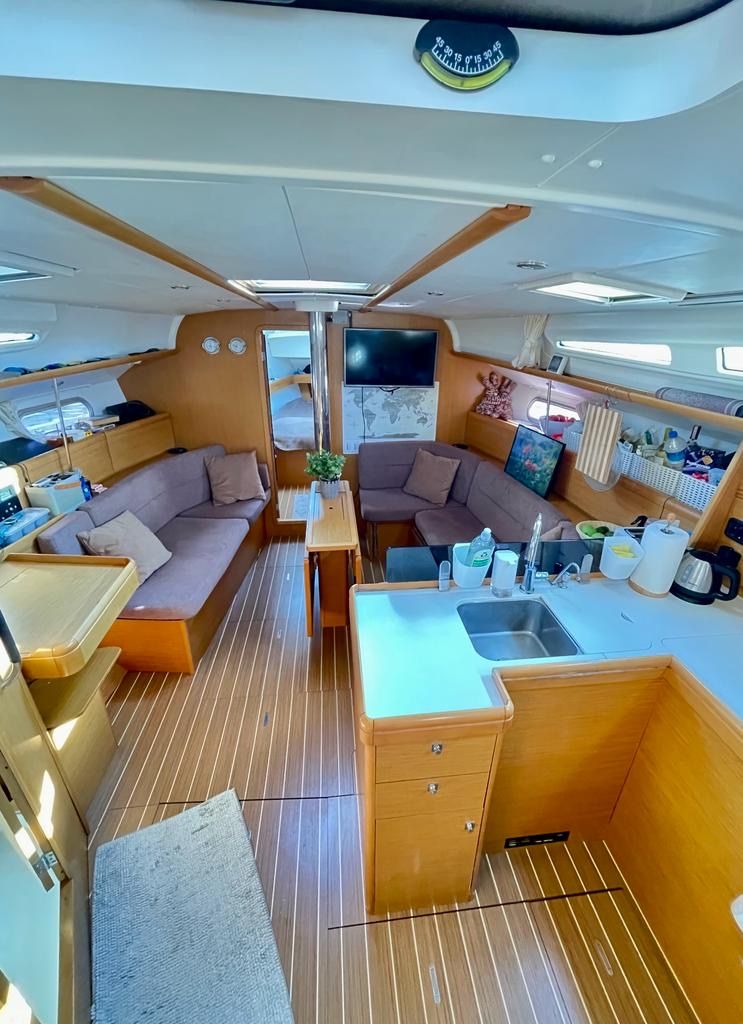 Салон Sun Odyssey 42: диваны, стол, камбуз с мойкой, деревянный пол